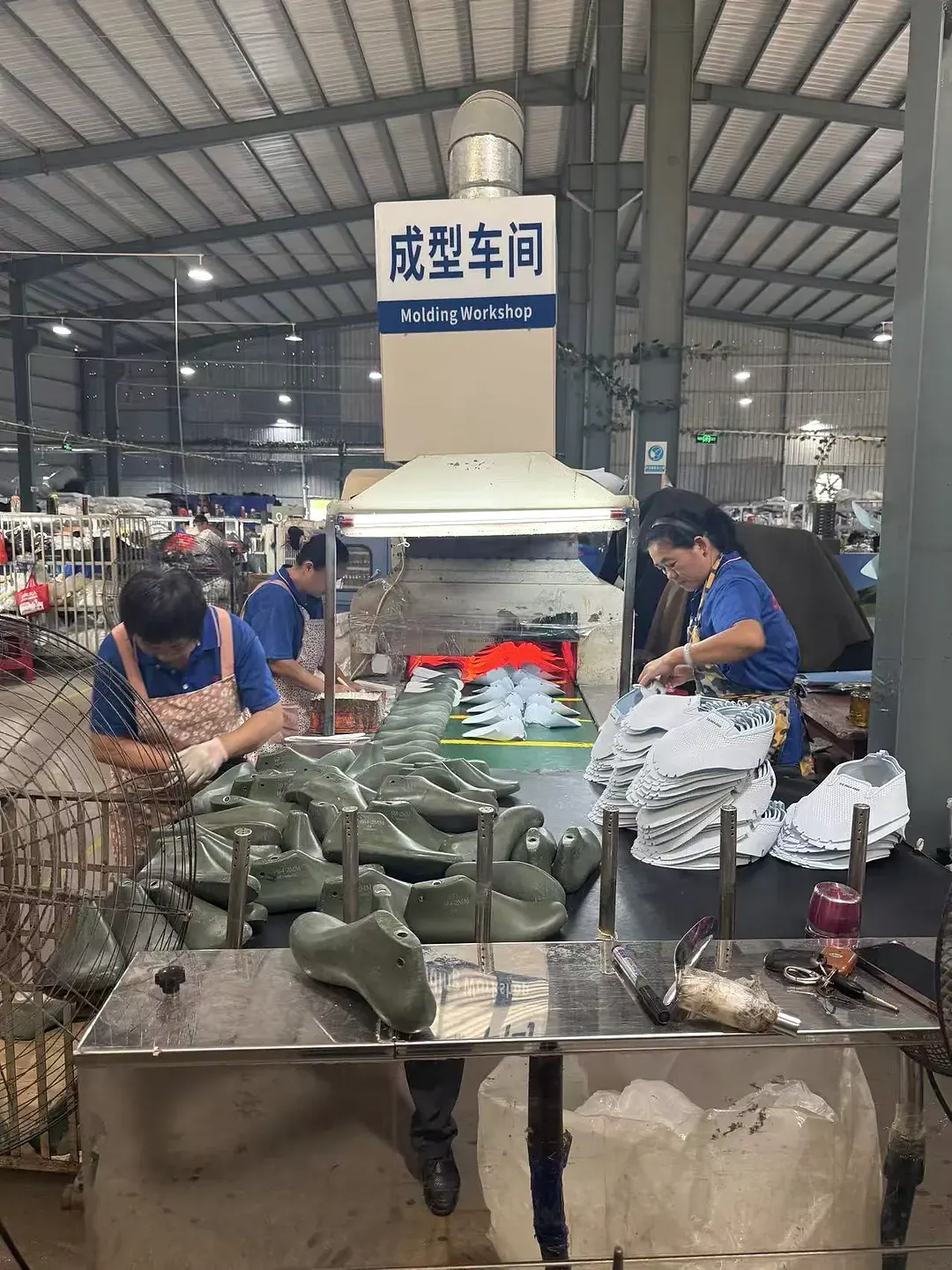 Employee working at a footwear production workstation inside the GRAND STAR factory