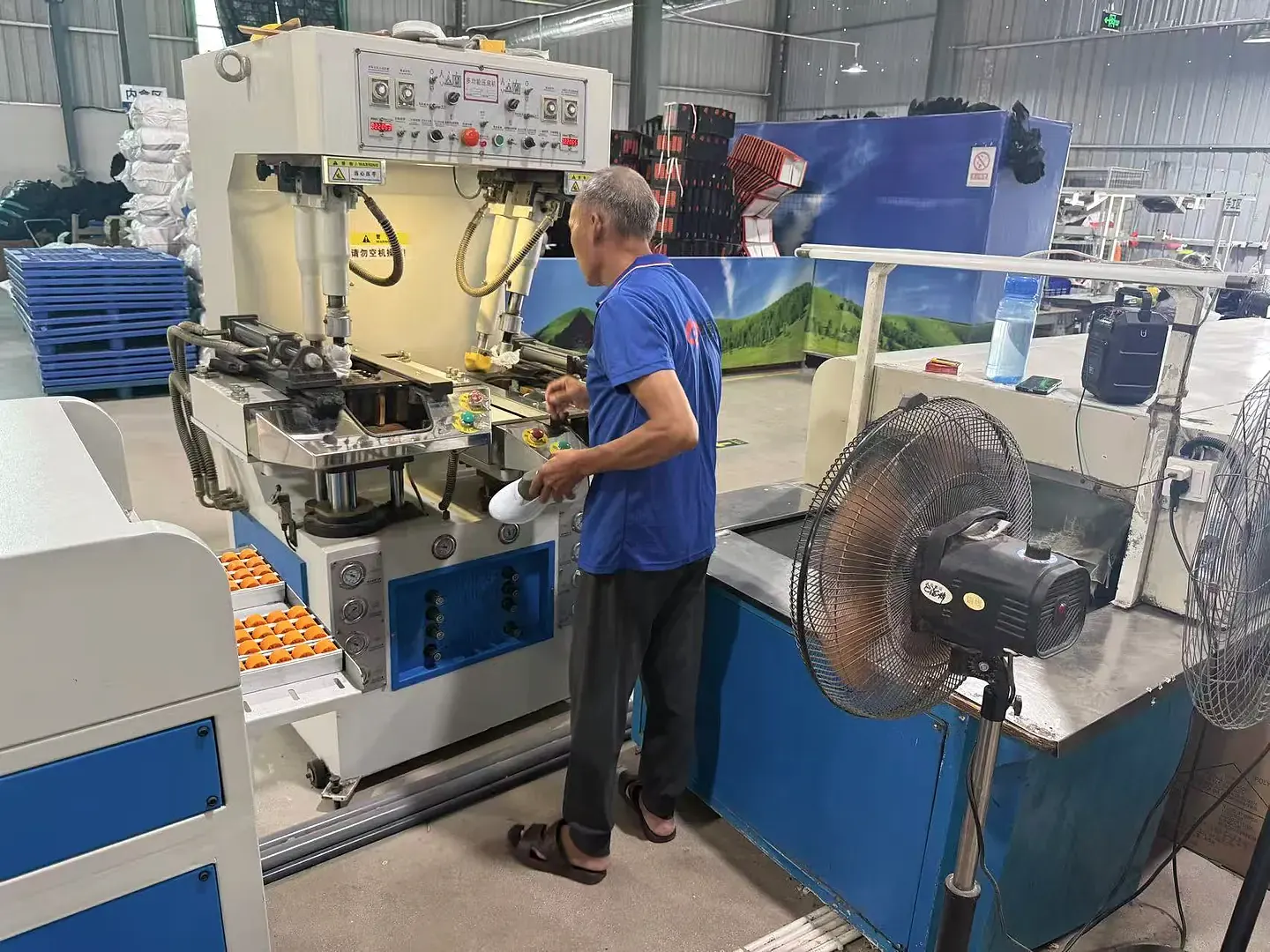 Factory staff working with footwear production press equipment